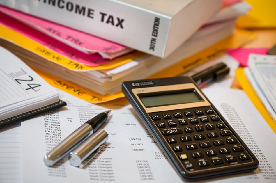 Image of a calculator and tax books for handling taxes on photograpahy invoices